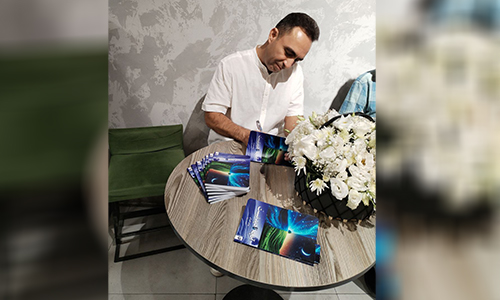 اقای مهدی کامرانی در حال امضای کتابی که نوشته بنام "آنچه نادیدنیست" از نشر نرنگ